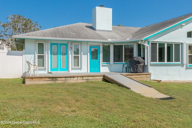 rear view of property with a yard and a deck