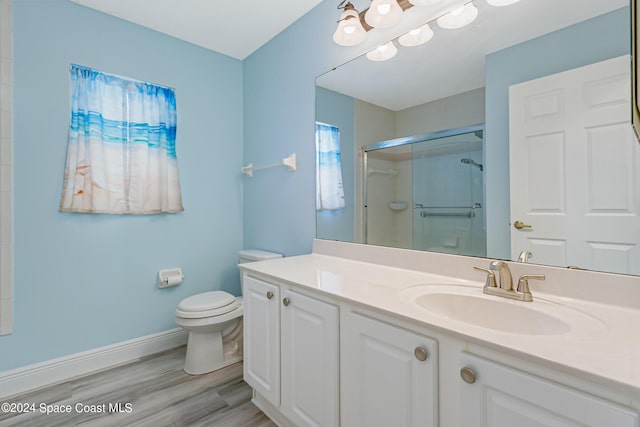 bathroom with a shower with door, vanity, hardwood / wood-style flooring, and toilet