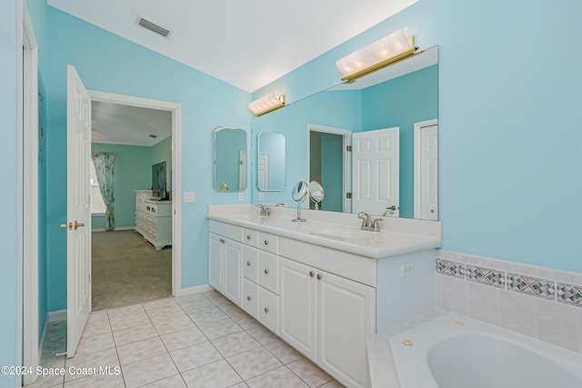 bathroom with vanity, lofted ceiling, a tub, and tile patterned flooring