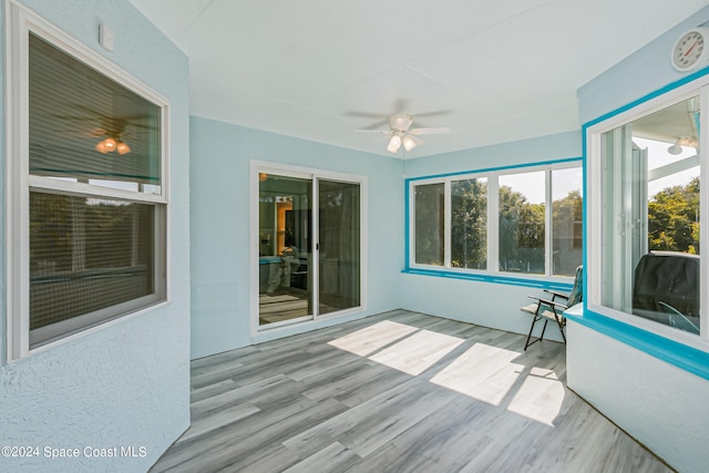 unfurnished sunroom featuring ceiling fan