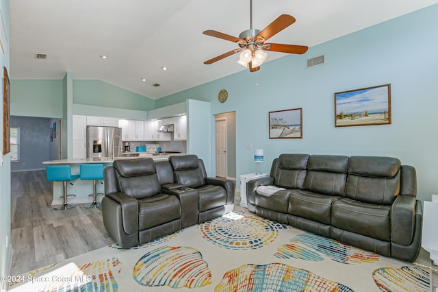 living room featuring lofted ceiling, light hardwood / wood-style flooring, and ceiling fan