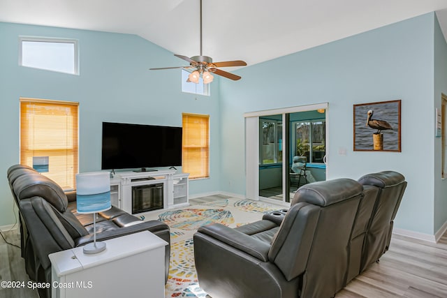 living room with light hardwood / wood-style floors, a healthy amount of sunlight, high vaulted ceiling, and ceiling fan