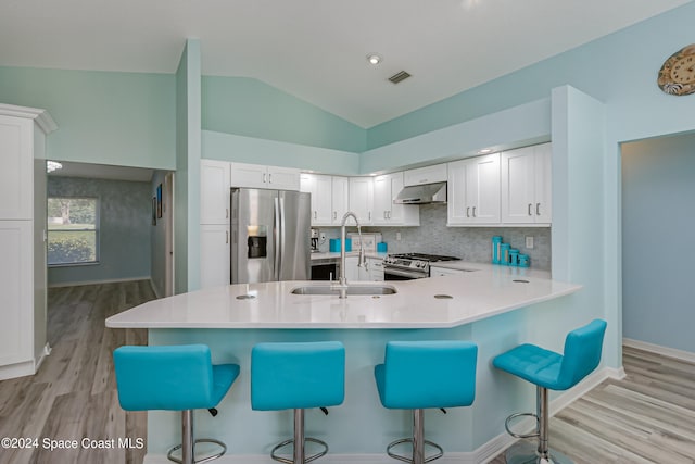 kitchen with white cabinetry, light hardwood / wood-style flooring, appliances with stainless steel finishes, and lofted ceiling