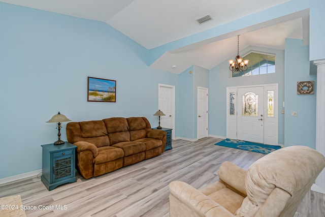 living room featuring a notable chandelier, high vaulted ceiling, and light wood-type flooring