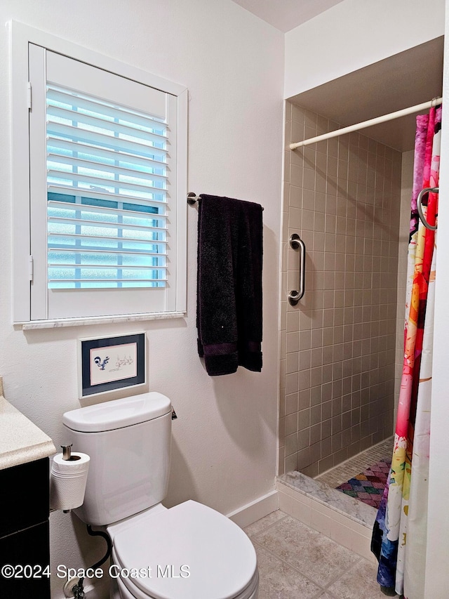 bathroom with tile patterned floors, a shower with curtain, vanity, and toilet