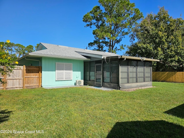 rear view of property with ac unit, a yard, and a sunroom