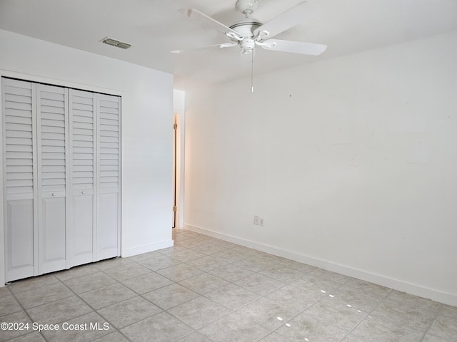 unfurnished bedroom featuring ceiling fan, light tile patterned floors, and a closet