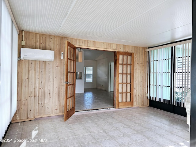 spare room featuring a wealth of natural light, wooden walls, and a wall mounted air conditioner