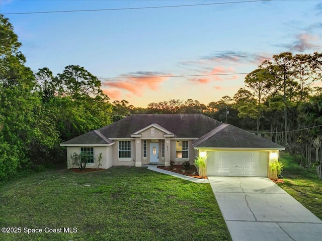 ranch-style house featuring a yard and a garage