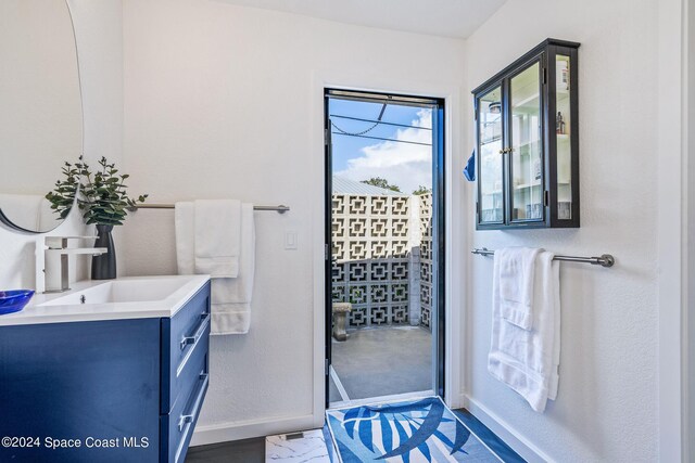 154 21st St SW, Vero Beach, FL 32962 - bathroom with a textured wall, baseboards, and vanity