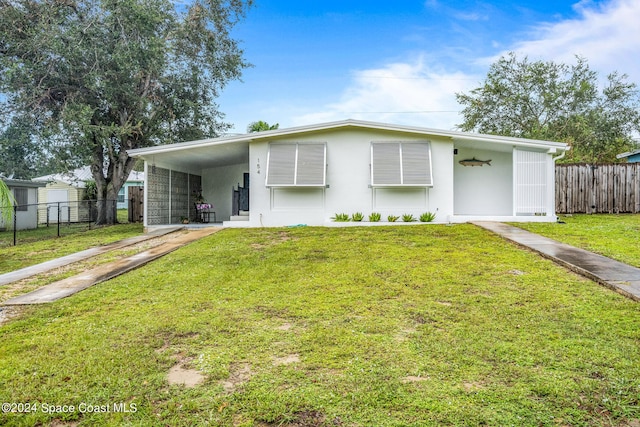 154 21st St SW, Vero Beach, FL 32962 - view of front facade with stucco siding, driveway, a front lawn, and fence