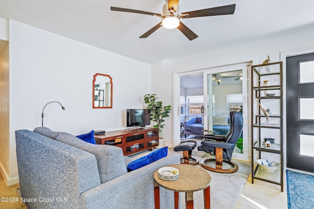 living room featuring a textured ceiling and ceiling fan