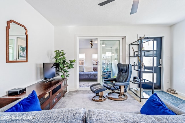 carpeted living room with ceiling fan, a textured ceiling, and a wealth of natural light