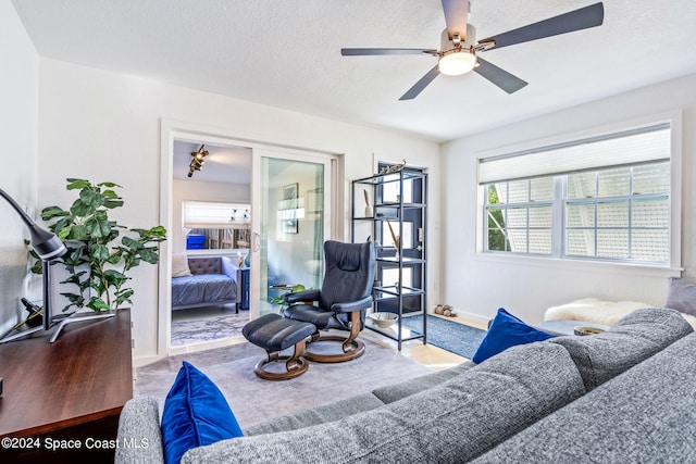 living room featuring a textured ceiling and ceiling fan