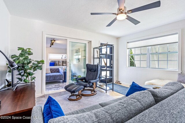 154 21st St SW, Vero Beach, FL 32962 - living area featuring baseboards, a ceiling fan, a textured ceiling, and plenty of natural light