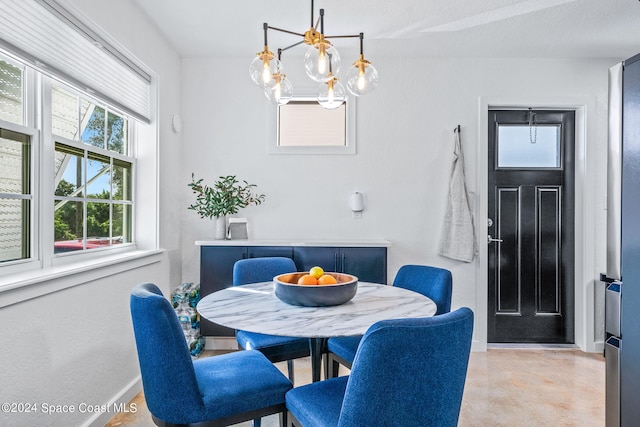 dining area featuring a notable chandelier and a textured ceiling