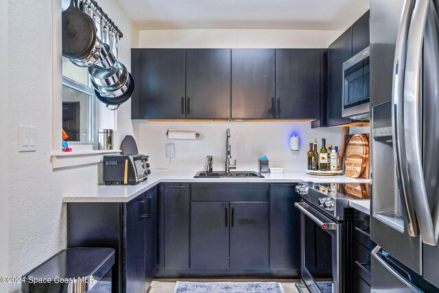 154 21st St SW, Vero Beach, FL 32962 - kitchen featuring dark cabinets, light countertops, a textured wall, a sink, and appliances with stainless steel finishes
