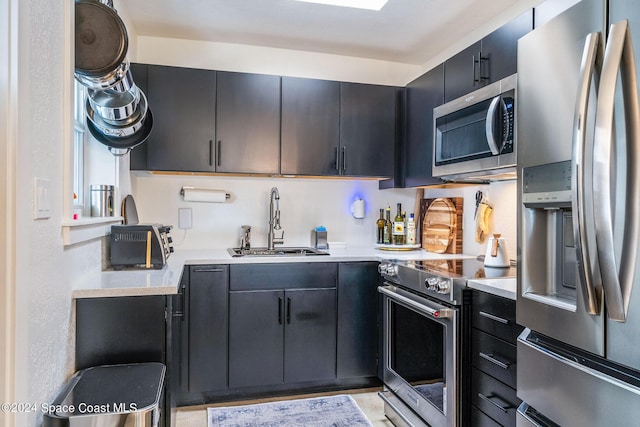 154 21st St SW, Vero Beach, FL 32962 - kitchen with dark cabinets, appliances with stainless steel finishes, a sink, and light countertops