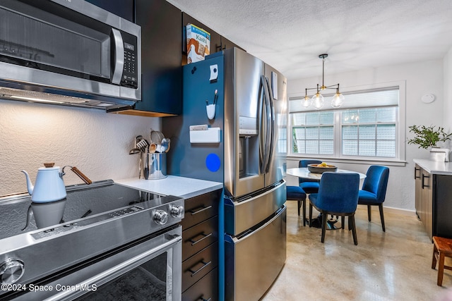 kitchen with appliances with stainless steel finishes, a textured ceiling, and decorative light fixtures