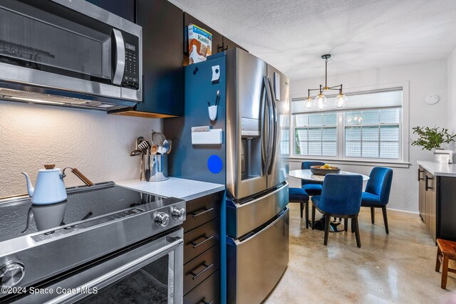 154 21st St SW, Vero Beach, FL 32962 - kitchen with light countertops, decorative light fixtures, concrete floors, and appliances with stainless steel finishes