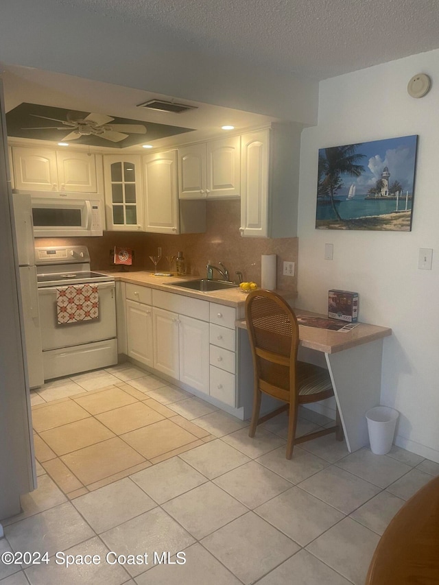 kitchen featuring sink, white cabinets, white appliances, and light tile patterned floors