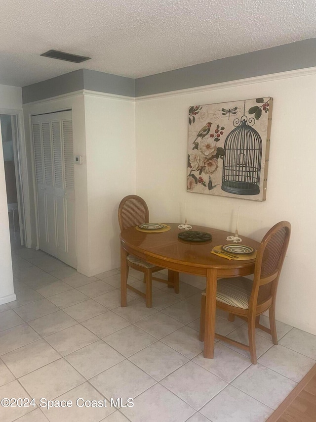 tiled dining space with a textured ceiling