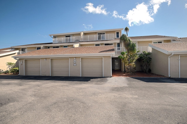 view of front facade featuring a garage and a balcony