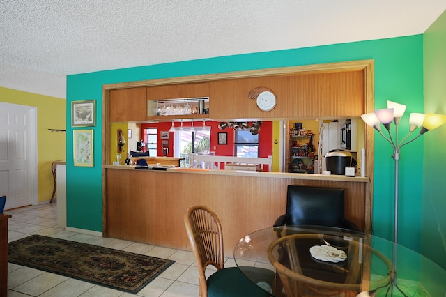 tiled dining room with a textured ceiling