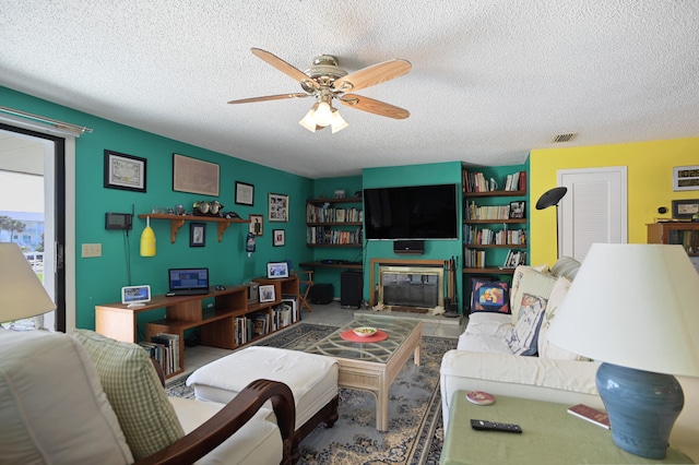 living room featuring ceiling fan and a textured ceiling