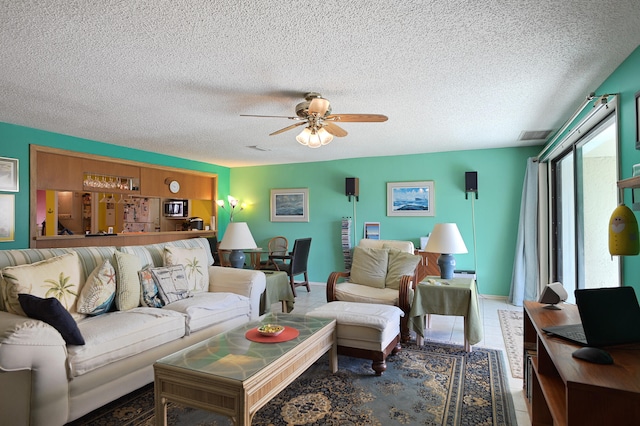 living room featuring a wealth of natural light, a textured ceiling, and ceiling fan