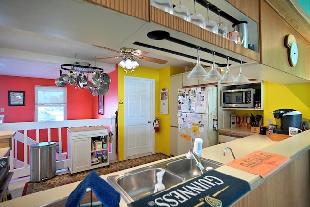 kitchen featuring ceiling fan, sink, and white refrigerator