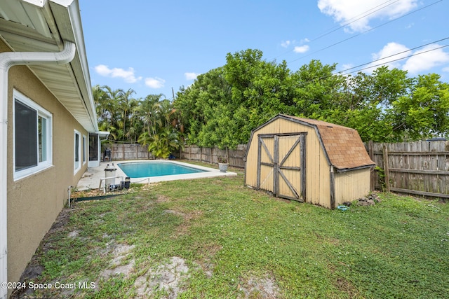 view of yard with a storage shed and a fenced in pool