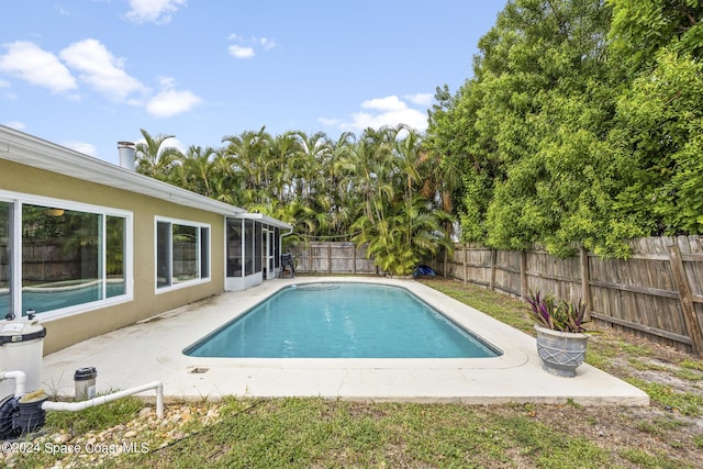 view of swimming pool with a fenced in pool, a sunroom, a patio, and a fenced backyard