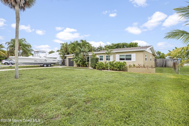 ranch-style home with stucco siding, a front lawn, fence, and a garage