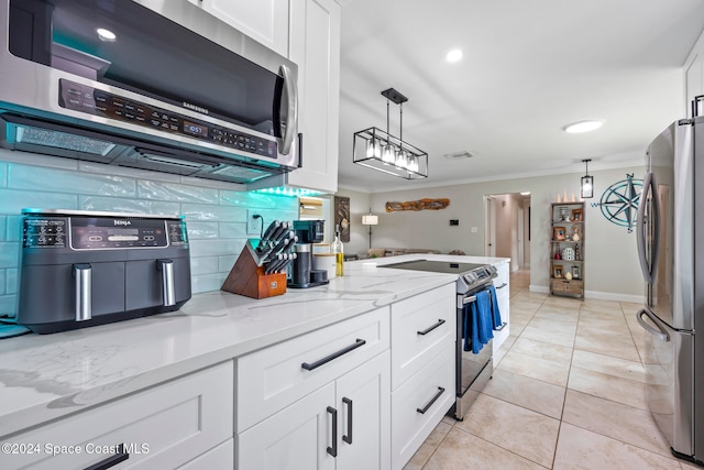 kitchen featuring hanging light fixtures, crown molding, appliances with stainless steel finishes, and white cabinets