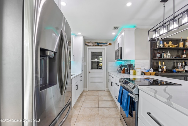 kitchen with light tile patterned floors, appliances with stainless steel finishes, backsplash, white cabinetry, and light stone countertops