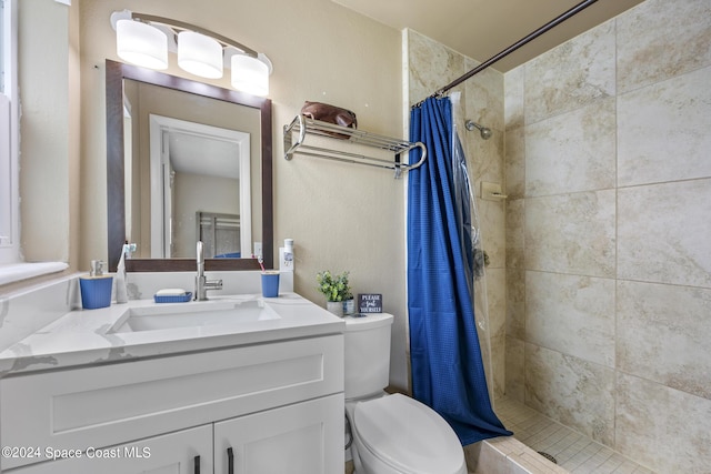 bathroom featuring a tile shower, toilet, and vanity