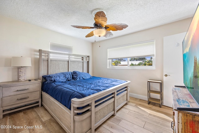 bedroom featuring ceiling fan, a textured ceiling, and light hardwood / wood-style flooring