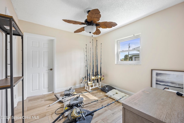 interior space with ceiling fan, a textured ceiling, and light hardwood / wood-style flooring