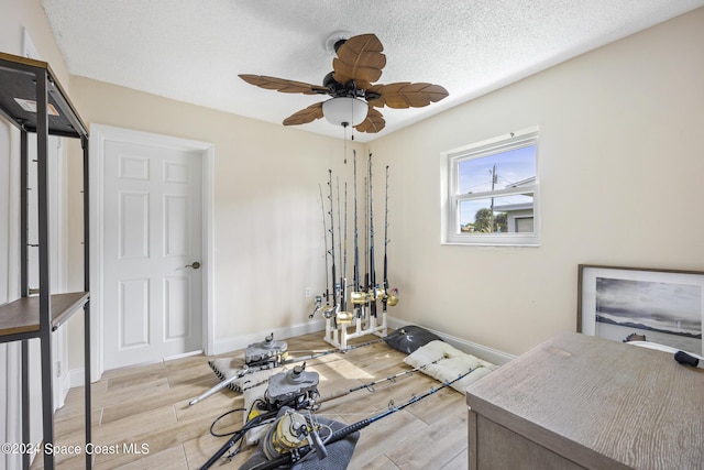 home office featuring baseboards, a ceiling fan, wood finished floors, and a textured ceiling