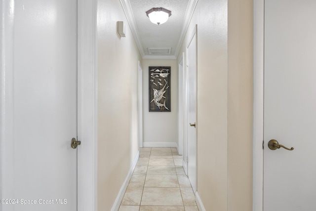 corridor with baseboards, a textured ceiling, and ornamental molding