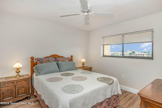 bedroom featuring baseboards, a ceiling fan, and wood finished floors