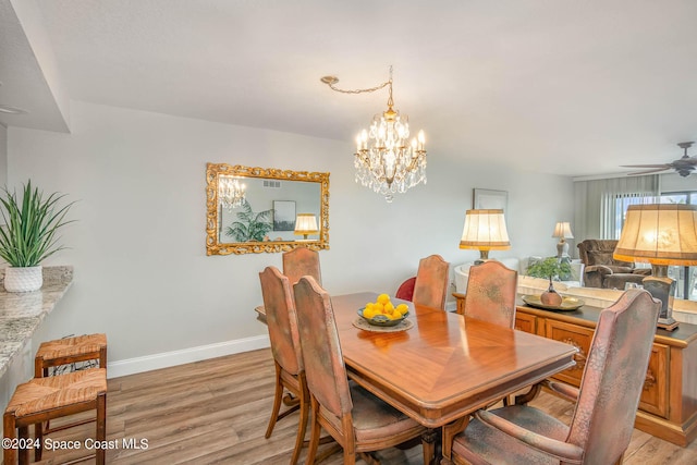 dining room with baseboards, light wood-style flooring, and ceiling fan with notable chandelier