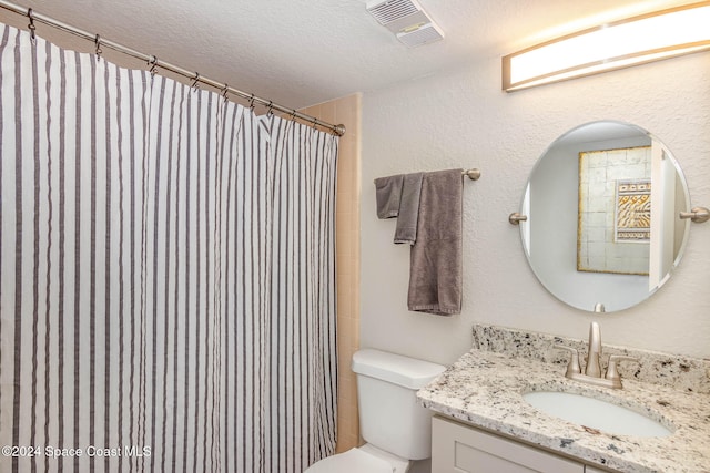 bathroom featuring vanity, a shower with curtain, a textured ceiling, and toilet