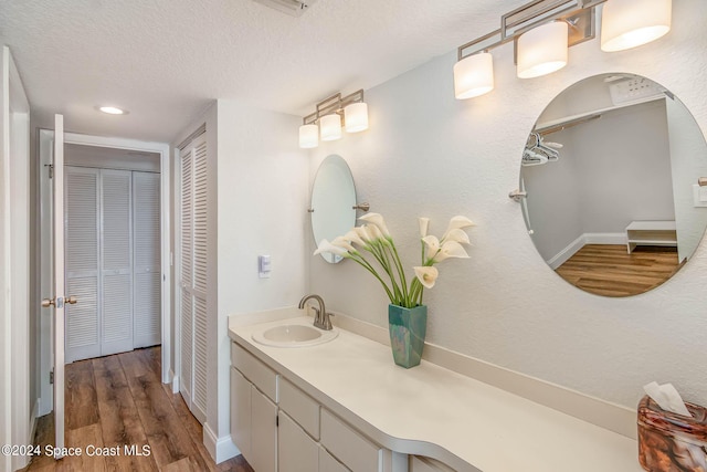 bathroom featuring a closet, a textured ceiling, wood finished floors, and vanity