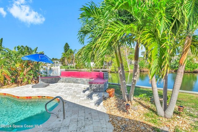 view of swimming pool with a patio and a water view