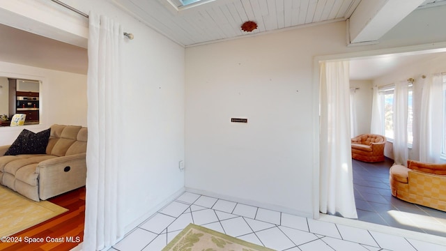 interior space featuring light tile patterned floors, a skylight, and wood ceiling