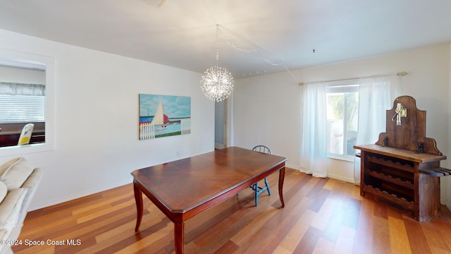 home office featuring hardwood / wood-style floors and a notable chandelier