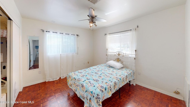 bedroom with a closet, ceiling fan, and dark parquet floors