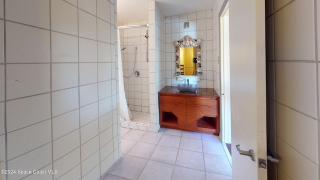 bathroom featuring tile patterned flooring, vanity, tile walls, and curtained shower